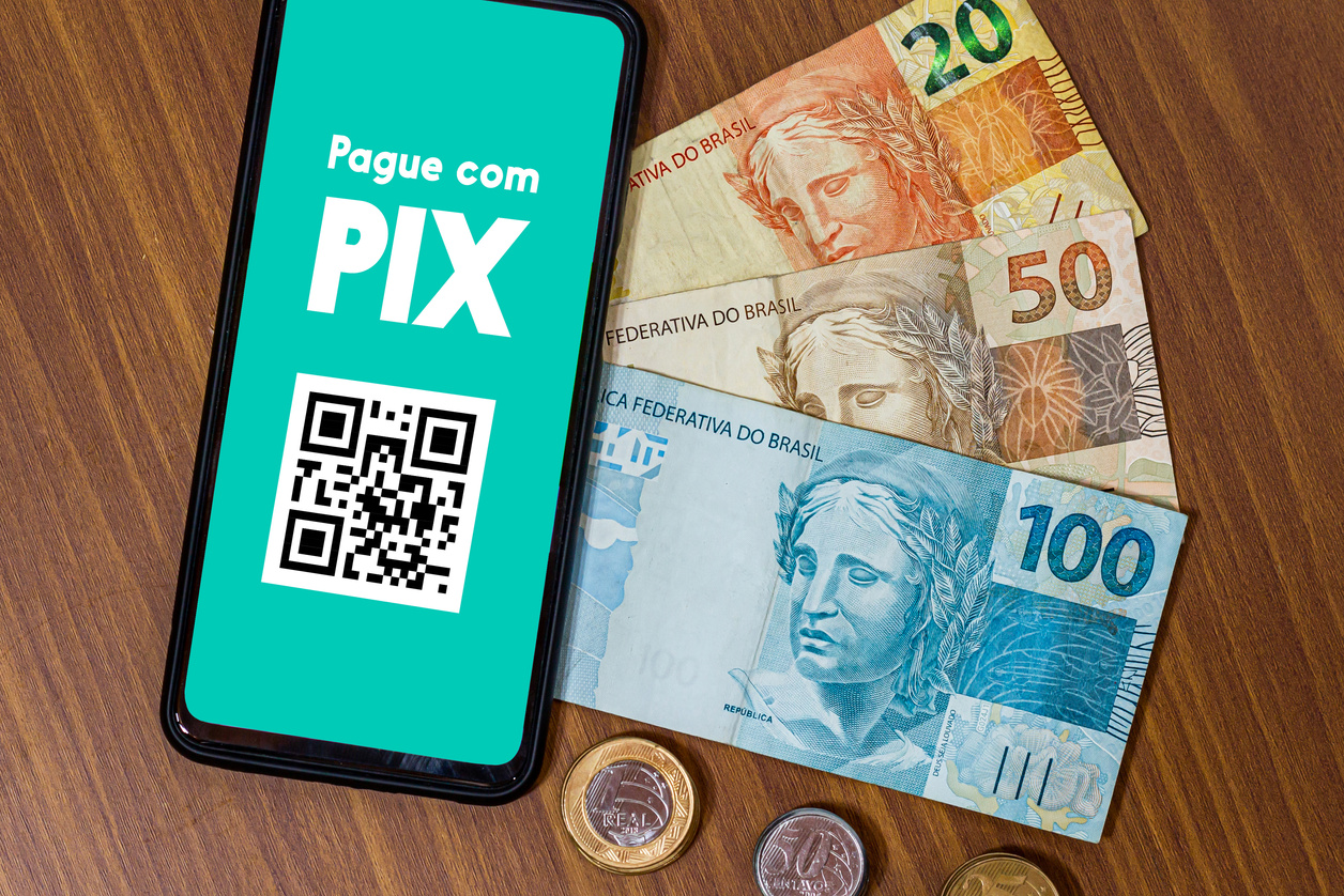 Pix on smartphone screen with multiple coins around. Pix is the new payment and transfer system of the Brazilian and Brazilian government.